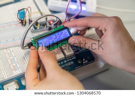 persons hands attach or install electric silicon chip or sensor