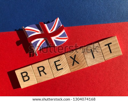 Brexit in wooden letter and a 3d Union Jack flag, isolated on a red and blue background
