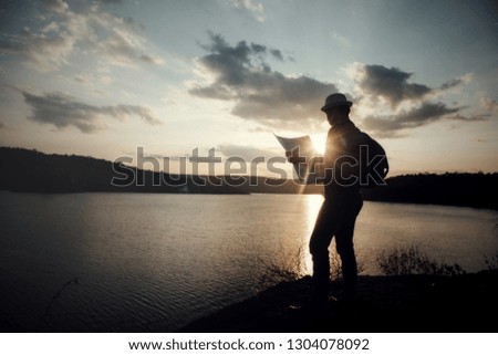 Tourist making photo of the nature, Man with map exploring wilderness on trekking adventure