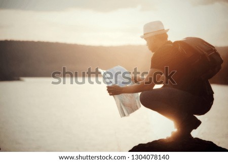 Tourist making photo of the nature, Man with map exploring wilderness on trekking adventure