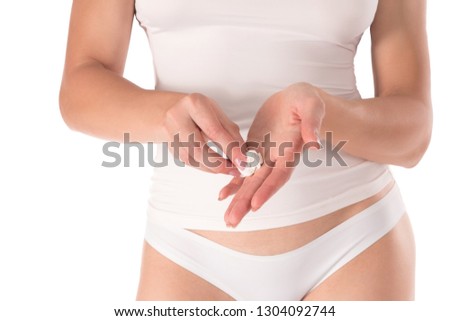 Woman cleaning her hands by white wet wipe, female well groomed fingers with French manicure, cropped fit body in white top and panties. Close up, isolated on a white. Beauty, skin and body care