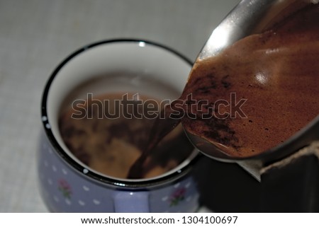 pouring hot coffee into the cup