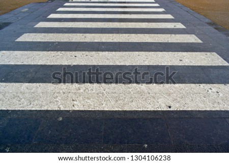Closeup of white and black pedestrian crosswalk on the road in the city center. Safety and take care concept.