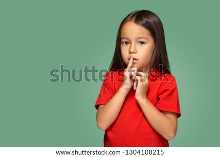 girl placing finger on lips asking shh, quiet, silence