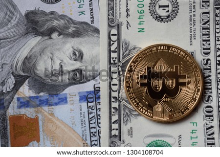 Golden Bitcoins on US dollars. Digital currency close-up. New virtual money. Crypto currency top view. Real coins of bitcoin on banknotes of one hundred dollars. Exchange. Bussiness, commercial.