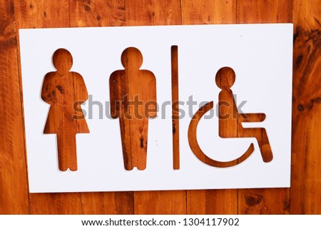 Restroom sign on a toilet door,on wood background.