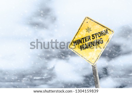 Winter storm season with snowflake symbol sign against a snowy background and copy space. Snow splattered and angled sign adds to the drama. Royalty-Free Stock Photo #1304159839