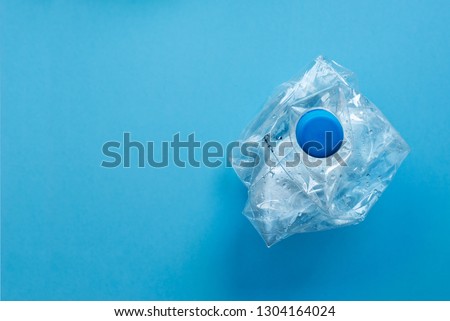 Used plastic bottles crushed and crumpled against on the blue background. Recycling concept Royalty-Free Stock Photo #1304164024