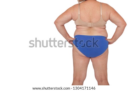 Menopausal woman with weight gain after brachioplasty, panniculectomy, abdominoplasty and mummy makeover. Full body back view hands on hips, copy space left. Makeover inspiration, faded scars. Royalty-Free Stock Photo #1304171146