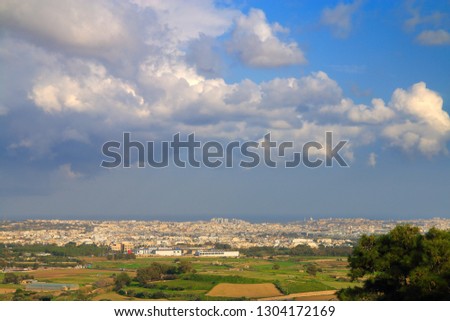 The photo was taken from the height of the ancient city of Mdina. The picture shows the landscape of the island of Malta with the coastal cities visible in the distance.