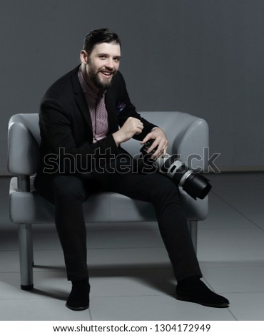 professional photographer sitting on an office chair.isolated on grey background