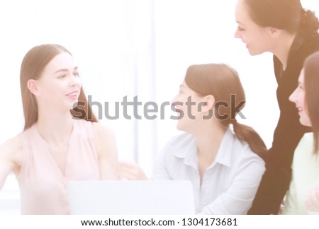 employees reading good news on line in a laptop sitting in a desktop at office.