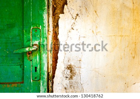 old door handle detail. wooden door on damaged wall close-up