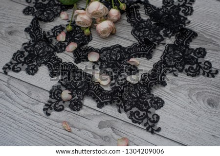 White wooden background with white spring flowers roses and lace ribbon. Happy womans day. The texture of lace on wooden background. Black