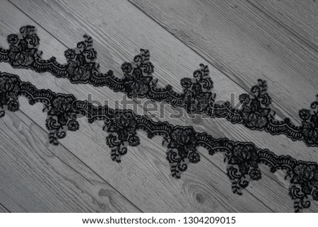White wooden background with white spring flowers roses and lace ribbon. Happy womans day. The texture of lace on wooden background. Black