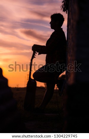 
Girl with guitar at sunset