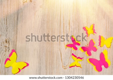 Colorful paper butterflies on wooden background. Children's developmental activity. Application and origami. Copy space