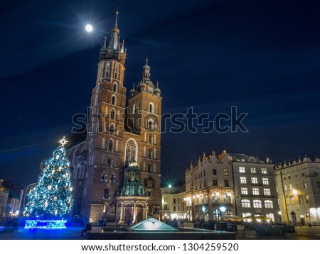 The night view of main square Rynek Glowny in Krakow old town Christmas city center with Bazylika Mariacka in the background. Krakow, Poland.