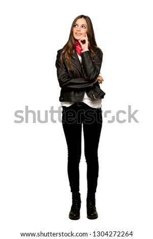 Full-length shot of Young woman with leather jacket thinking an idea while looking up on isolated white background