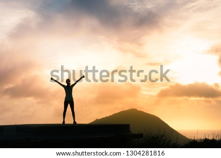 Young woman feeling motivated with thumbs up standing on a mountain.  Royalty-Free Stock Photo #1304281816