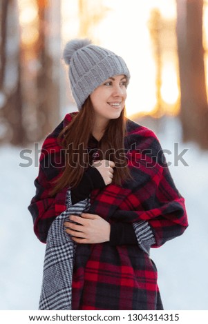 Pretty young caucasian woman portrait in winter forest. Sunset woman photograph with beautiful light