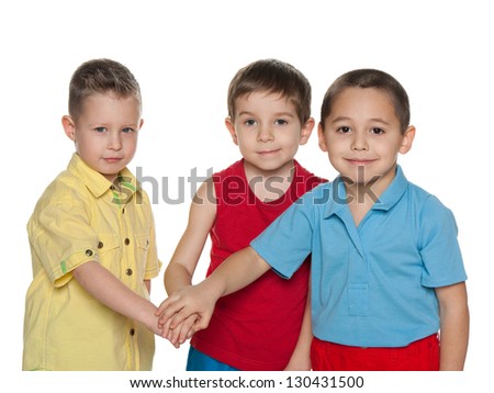 Three little boys stand together on the white background