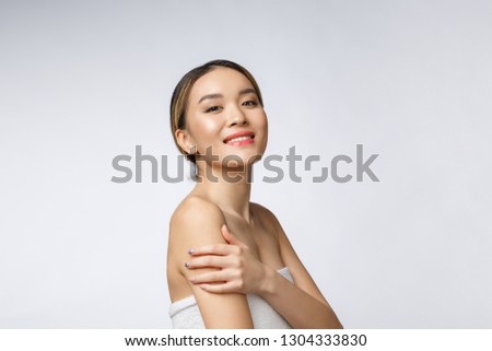 Sided portrait of Asian beautiful smiling girl with short hair showing her healthy skin on the isolated white background