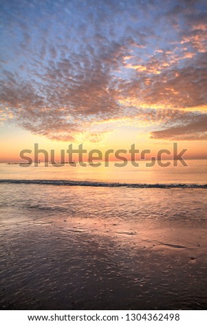 Ripples of waves under a sunset sky of red and orange at South Marco Island Beach in Florida