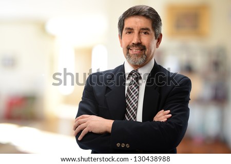 Mature Hispanic Businessman with arms crossed isolated on a white background Royalty-Free Stock Photo #130438988