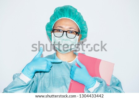Doctor or surgeons wear glasses in grown uniform and mask show finger focus to a patient's medical record,Surgery doctor holding and reading a patient illness report in file or clipboard,Health care,