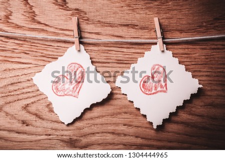 two blank sheet with painted hearts on a rope