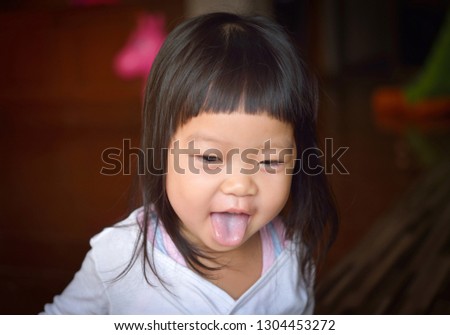 asian baby girl showing her tongue in the home