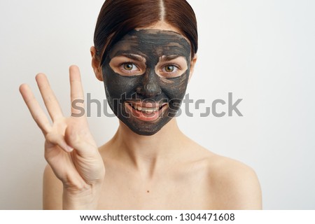 woman in a cosmetic mask on her face shows fingers portrait