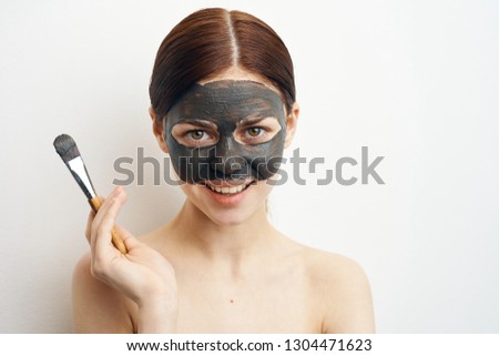 woman in clay mask in hand brush