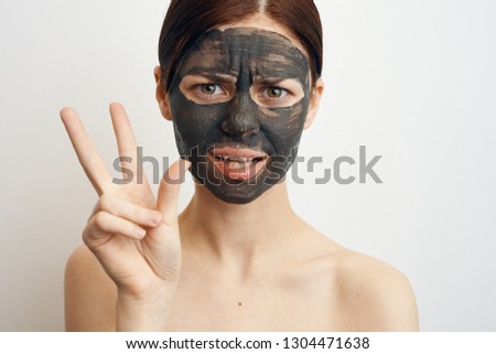 woman in a cosmetic mask on her face shows fingers portrait