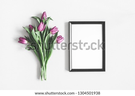 Flowers composition. Purple tulip flowers, photo frame on pastel gray background. Valentines day, mothers day, womens day, spring concept. Flat lay, top view, copy space