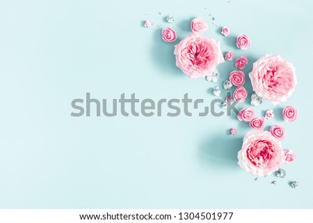 Flowers composition. Frame made of rose flowers on pastel blue background. Valentines day, mothers day, womens day, spring concept. Flat lay, top view, copy space Royalty-Free Stock Photo #1304501977