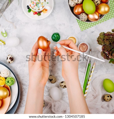 Workspace with easter decoration. Woman paints Easter eggs. Flat lay, top view