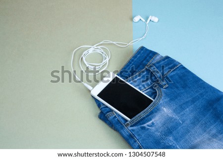 top view flat lay  smartphone in  jeans pocket on a green and blue background, summer clothing set women's fashion 