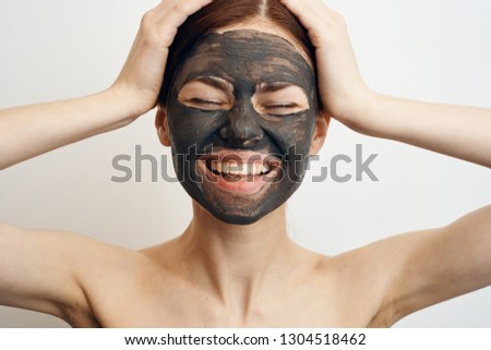 happy woman with closed eyes in clay mask on face portrait