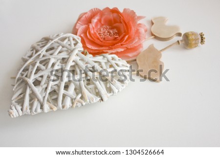 Valentines Day white background with a white big heart, pink rose and wood decoration