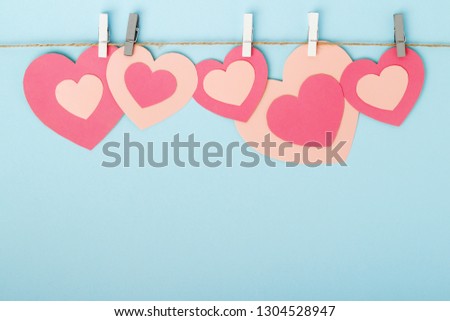 Pink paper hearts hanging at a rope for Valentine's Day, Mother's Day or Women's Day decoration with copy space