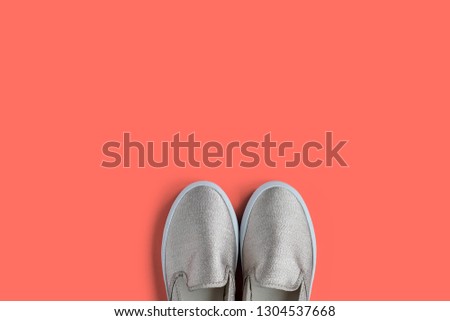 Trendy shoes with glitter on coral pantone of the year background with empty space for text