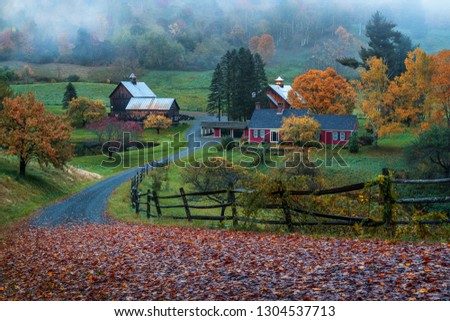 Iconic Vermont Farmstead Sleepy Hollow on a foggy dusky evening in Autumn with fall foliage 