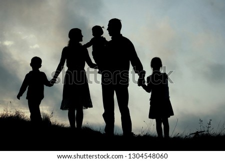 silhouette of a happy family with children on nature
