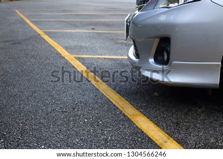yellow line marking car parking lots on black asphalt road