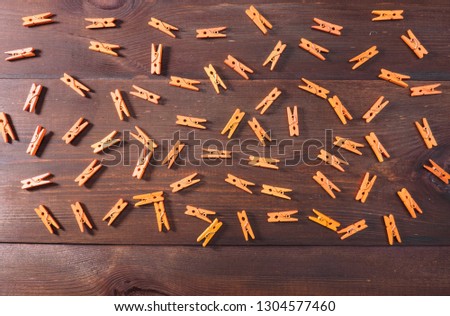 Orange clothes pegs on brown wood background