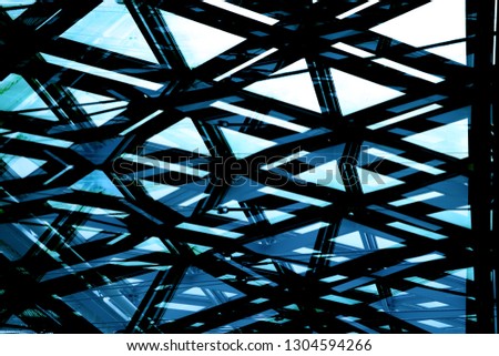 Toned photo of modern modular glass ceiling with cable track lighting system. Abstract geometric background in grunge technique on the subject of contemporary architecture or interior.