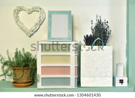 Paper bag with lavender, succulent plant and picture frame on wooden shelf. Loft life style home decoration on vintage shelf, mockup background