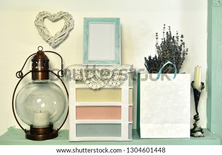 Old lamp, picture frame with blank, paper bag with lavender bunch and box on shelf. Loft life style home decoration on vintage shelf, mockup background